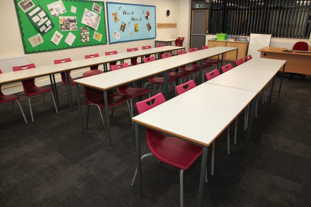 White desks with red chairs in a classroom