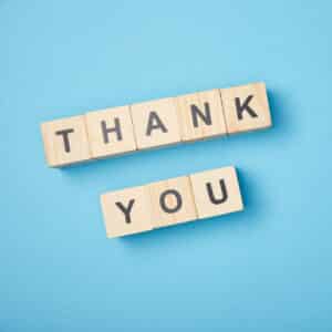 Top View Of Wooden Cubes With Thank You Words On Blue Background